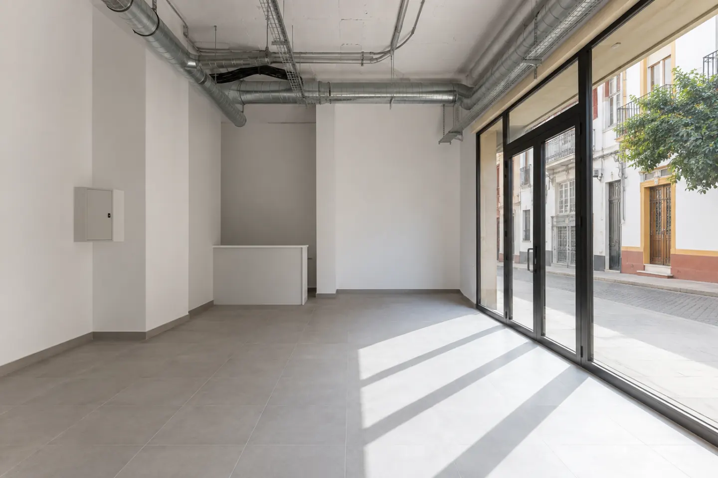 Interior de un local comercial recién acondicionado y todavía vacío, con las instalaciones vistas